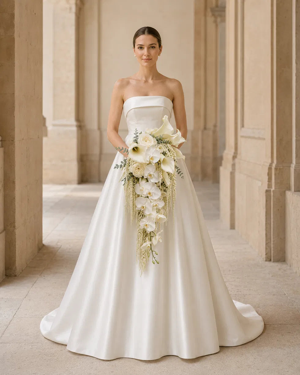 Ivory Cascade calla lily and orchid bridal bouquet, bride standing full-body in strapless gown, studio hero front shot