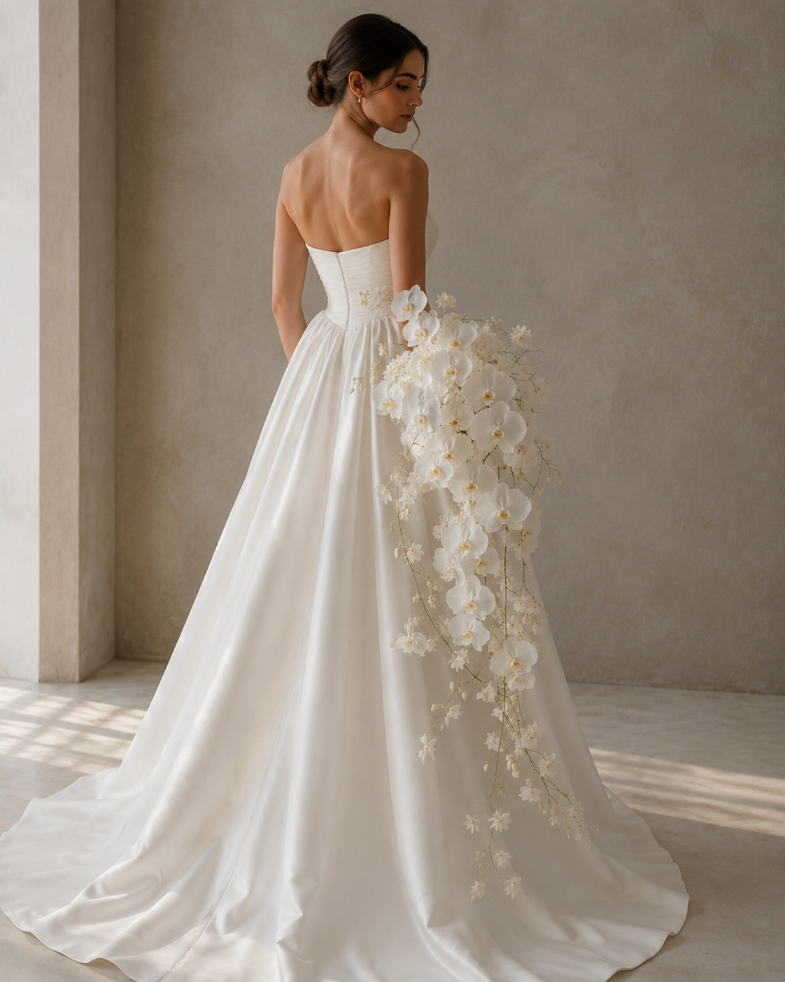 Back view of bride holding Phalaenopsis Waterfall cascading white orchid bridal bouquet against dress train